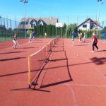 Dziewczyny i chłopcy grają w mini tenisa
