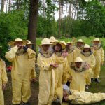 Grupa dzieci w kombinezonach pszczelarskich