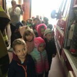 dzieci oglądające wyposażenie wozu strażackiego