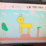 ekran monitora na którym wykonany jest rysunek żółtego kota stojącego na brązowej górce