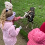 Dzieci karmiące kozę
