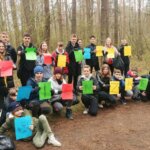 Uczniowie w lesie trzymają napisy Dzień Ziemi w języku polskim i ukraińskim.