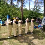 Dzieci stoją w szeregu w oczekiwaniu na poszukiwanie Królowej pszczół