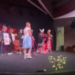 Dzieci przebrane w stroje z Alicji w krainie czarów występują na scenie