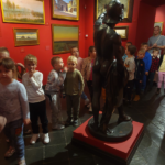 Dzieci obserwują eksponaty w muzeum