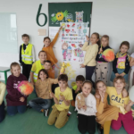 Dzieci w żółtych strojach prezentują plakat na dzień życzliwości