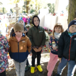 Grupa dzieci stoi na cmentarzu