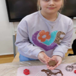 Dziewczynka pokazuje piernika wykrojonego z ciasta