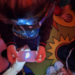 dziecko podświetla latarką wylosowaną kartę z wróżbą