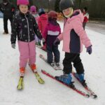 Dwie dziewczynki stoją na nartach
