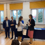 Członkowie komisji konkursowej wręczają nagrodę uczennicy