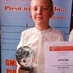 Uczeń pokazuje dyplom i nagrodę