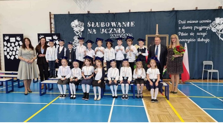Zdjęcie grupowe dzieci na zakończenie ślubowania z lewej strony pani dyrektor, pani burmistrz, z prawej strony pan dyrektor , wychowawca klasy