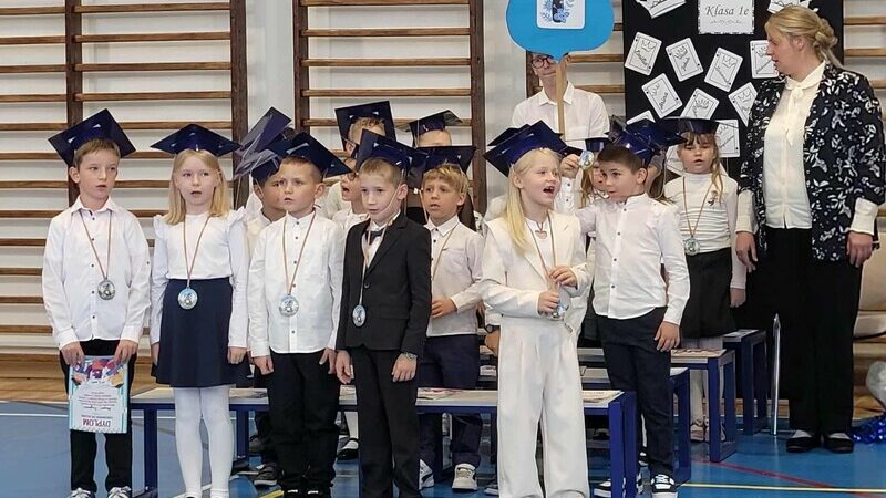 Grupa dzieci z klasy 1e stoi i śpiewa piosenkę