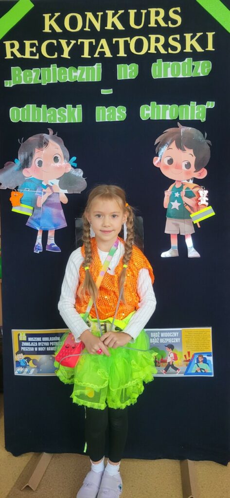 Dziewczynka w odblaskowym stroju recytuje wiersz