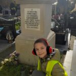 Uczeń zapala znicz przy pomniku powstańca styczniowego.