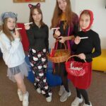 Cztery dziewczynki stoją obok siebie w strojach postaci z bajek