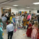 Duża grupa dzieci tańczy w strojach postaci z bajek