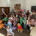 Duża grupa dzieci z nauczycielką w strojach postaci z bajek