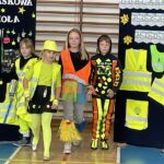 Czterech uczniów prezentuje stroje odblaskowe.