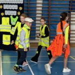 Czterech uczniów prezentuje stroje odblaskowe.