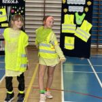 Dwie dziewczynki prezentują stroje odblaskowe.