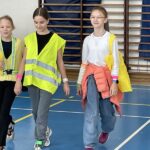 Trzy dziewczynki prezentują modę odblaskową.