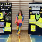 Dziewczynka prezentuje strój odblaskowy.