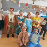 Pięcioro dzieci stoi, dwoje siedzi przed nimi - wszyscy w strojach postaci z bajek