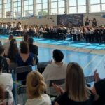 Społeczność szkolna w raz z rodzicami zgromadzona na sali gimnastycznej na pożegnaniu klas ósmych.