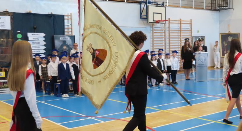Uczeń idzie ze sztandarem szkoły